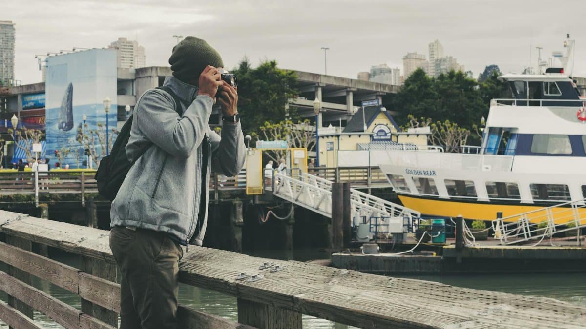 A photographer captures the San Francisco waterfront with a docked ferry in the backdrop.
