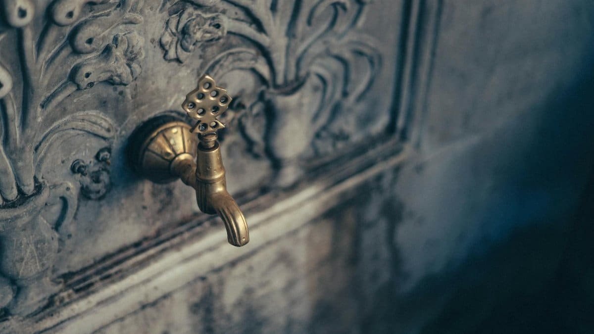 Close-up of a decorative brass faucet on a carved stone wall in Üsküdar, İstanbul.