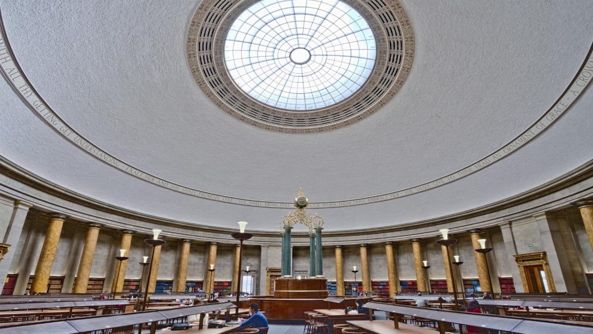 Panoramic view of Manchester Central Library's stunning reading room with grand dome and vintage architecture.
