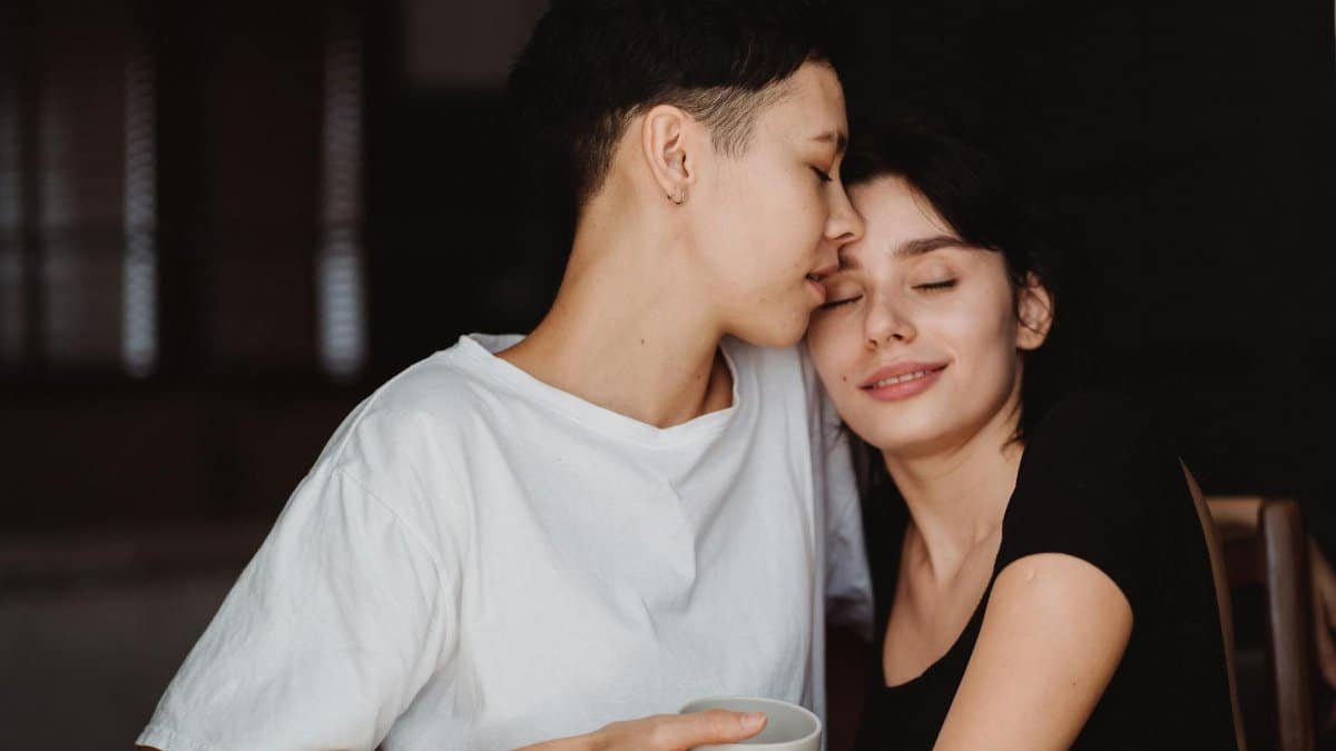 A loving couple embraces indoors, exuding warmth and connection.