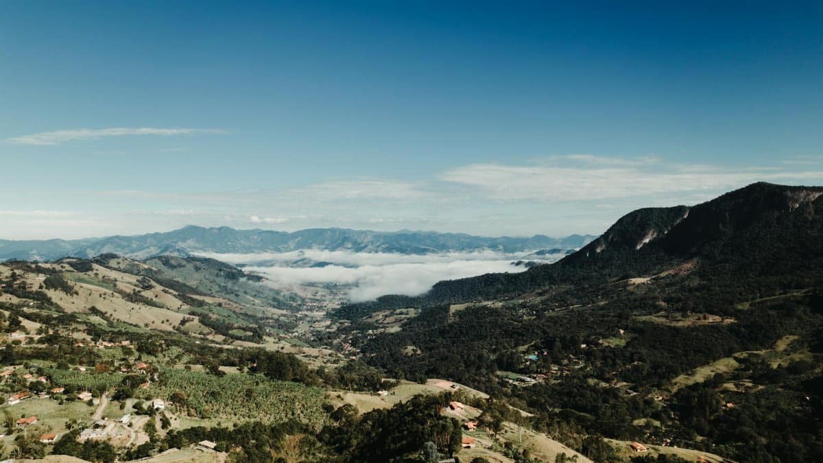 Beautiful aerial view of a mountainous valley beneath a clear blue sky, capturing the essence of nature's beauty.