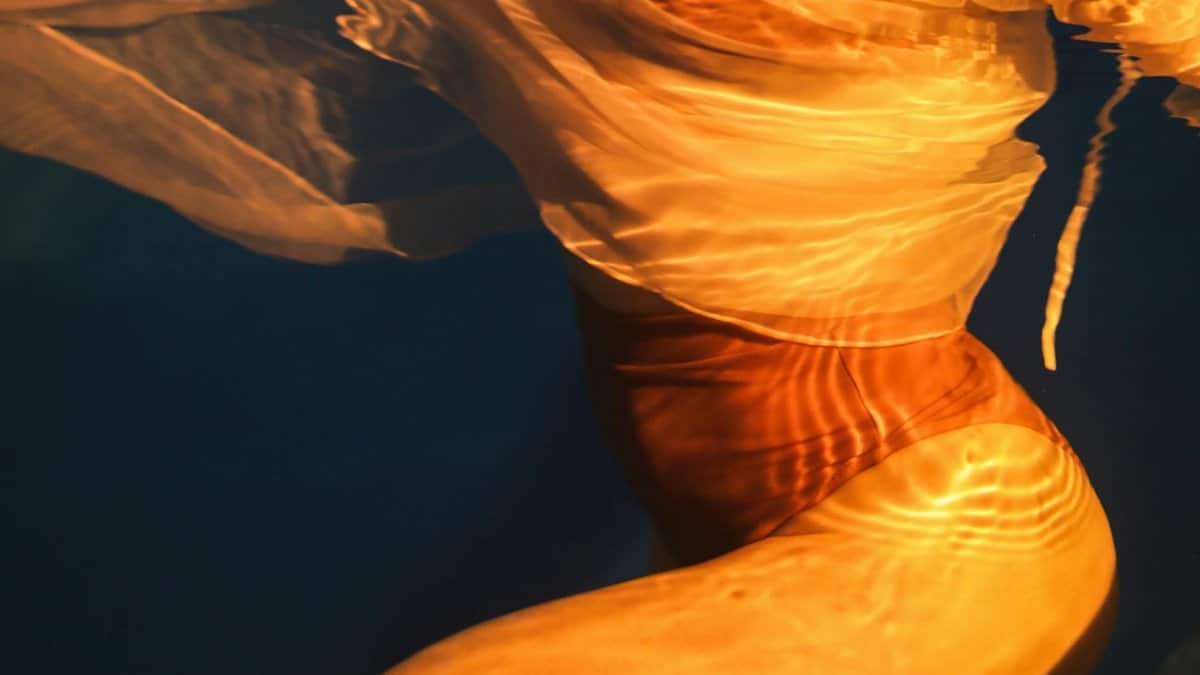 Abstract underwater image highlighting the flow and colors of swimwear.