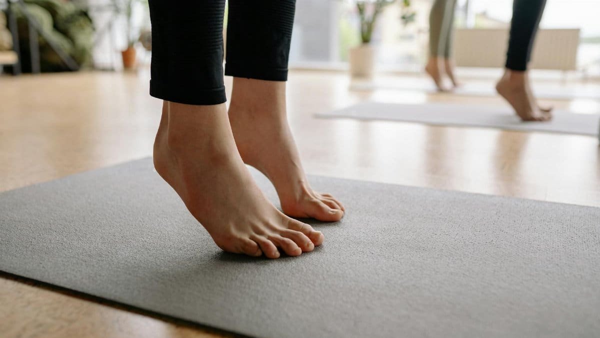 Close-up of bare feet during a yoga session indoors, focusing on mindfulness.