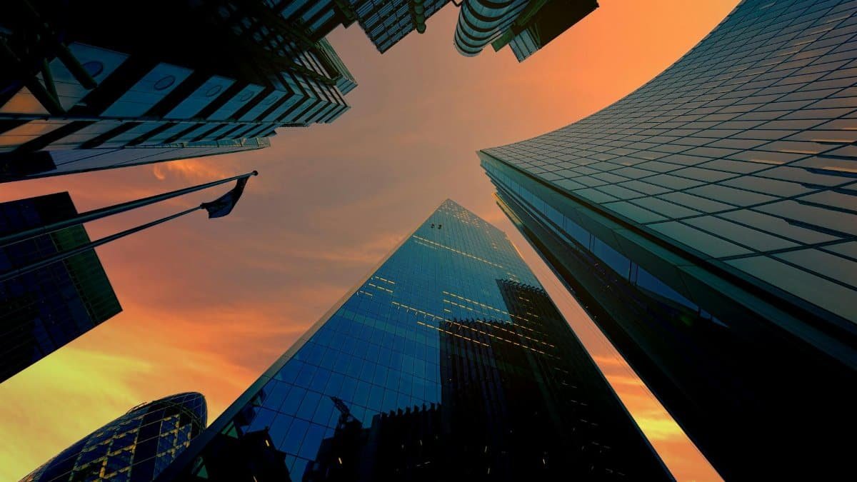 Low angle view of modern skyscrapers against a vibrant sunset sky.