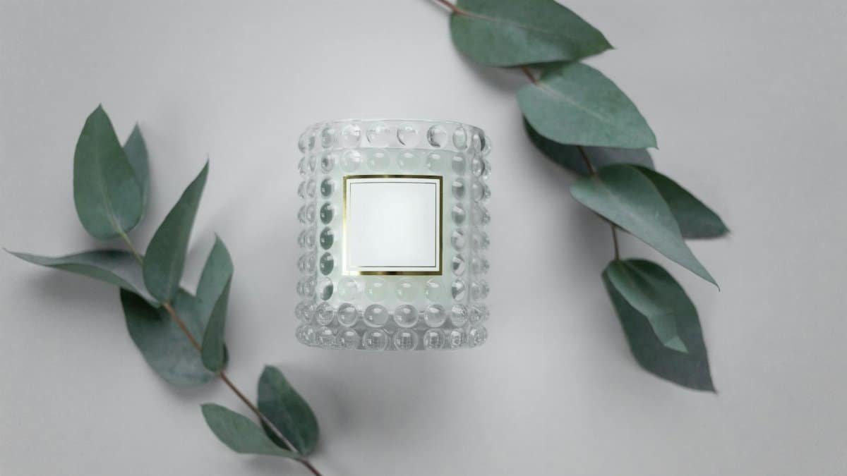 Elegant still life of a scented candle with eucalyptus leaves, perfect for aromatherapy themes.