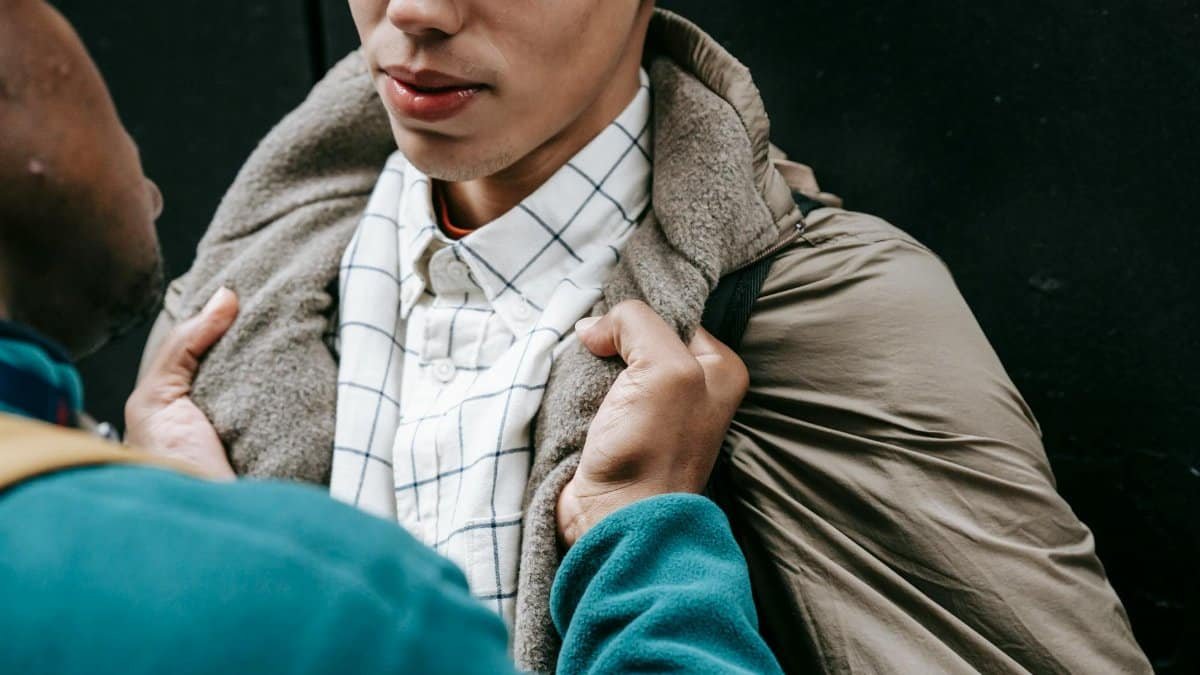 A tense moment between two young men captured outdoors, highlighting confrontation.