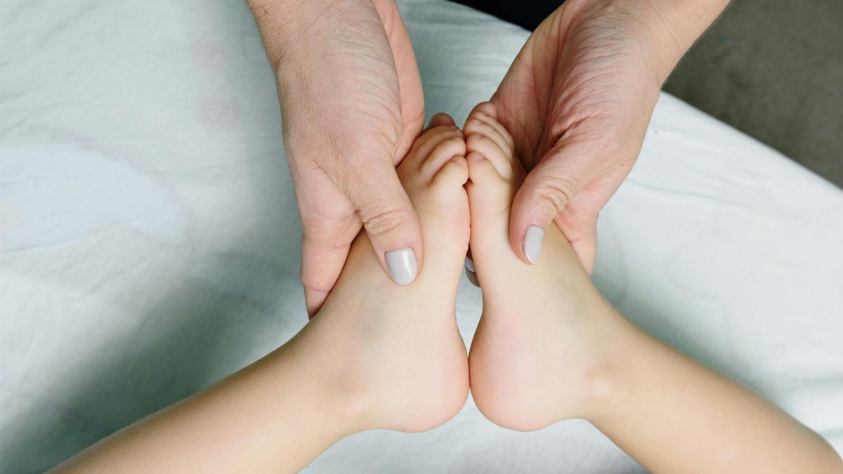 Adult hands gently massaging baby feet. Perfect representation of care and relaxation.