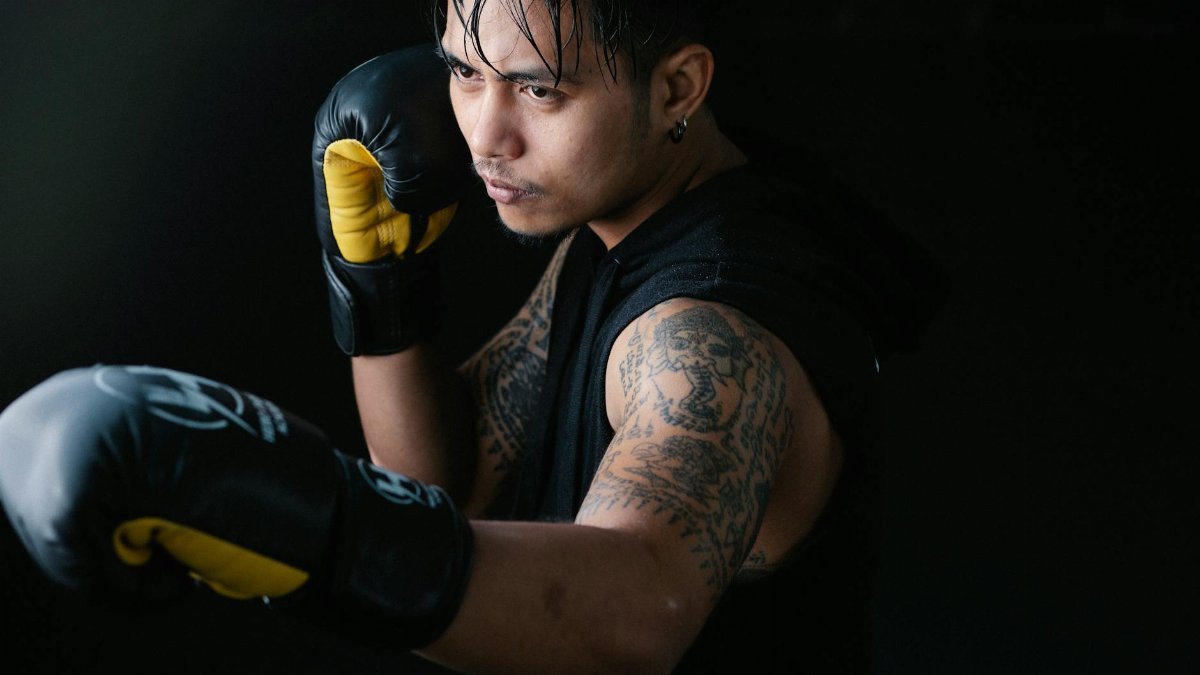 Close-up of a boxer practicing punch technique, wearing gloves and focused on training.