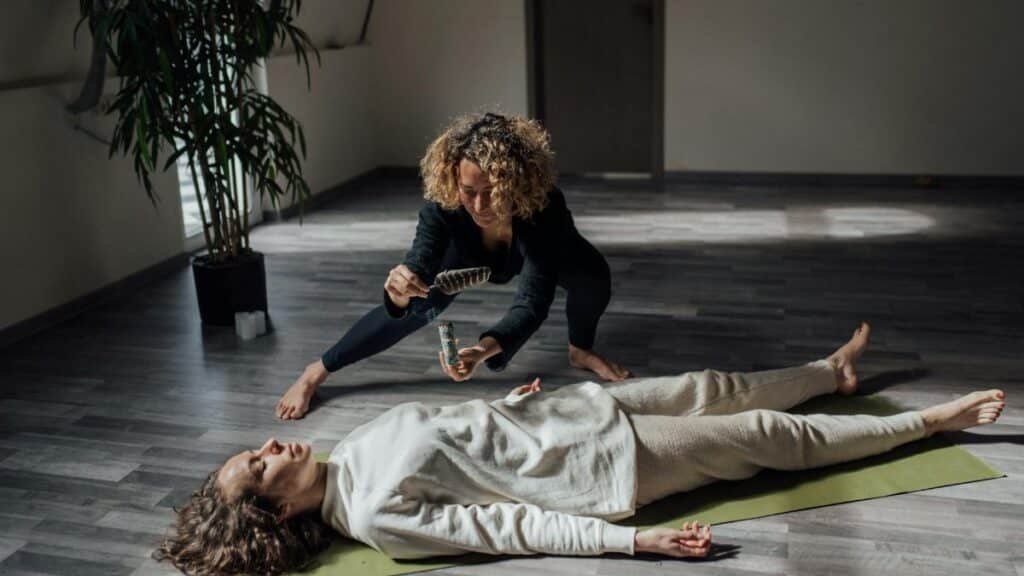A reiki healer uses white sage in a calming indoor setting for a spiritual healing ritual.