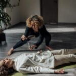 A reiki healer uses white sage in a calming indoor setting for a spiritual healing ritual.