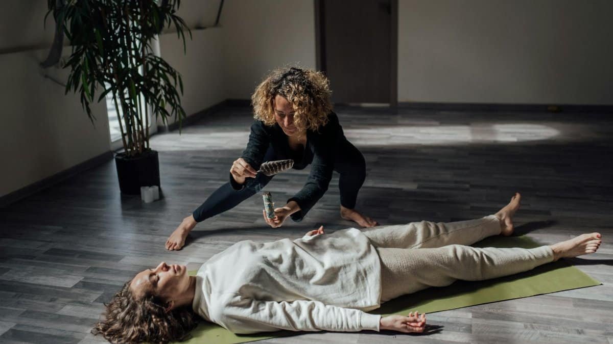 A reiki healer uses white sage in a calming indoor setting for a spiritual healing ritual.