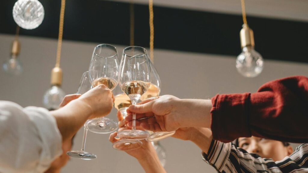 Group of friends celebrating with a toast of wine glasses indoors.