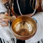 A woman holding a singing bowl, engaging in a peaceful meditation practice.