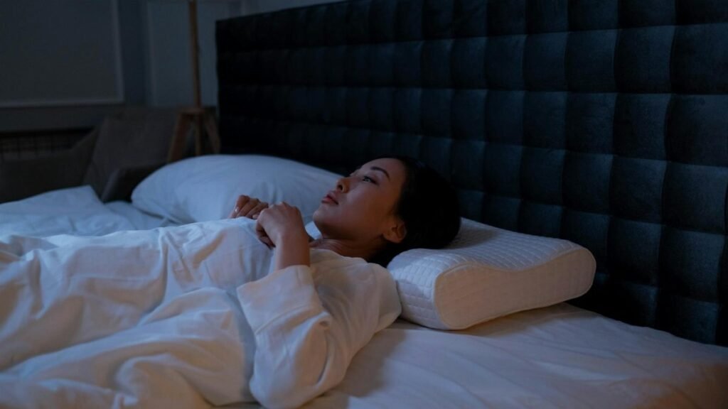 An Asian woman lying awake in bed at night, showing signs of insomnia and sleeplessness.