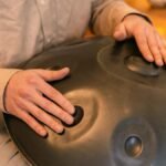 A person plays a handpan instrument, focusing on relaxation and zen vibes indoors.