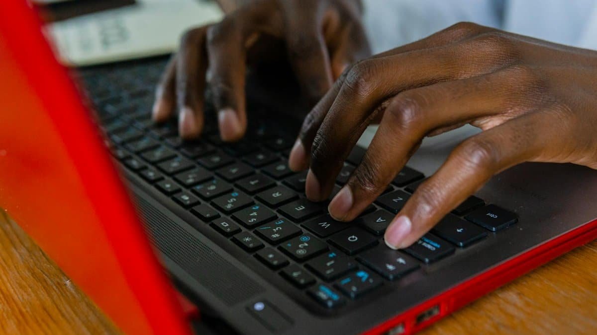 A detailed shot of hands typing on a laptop keyboard, highlighting tech engagement.