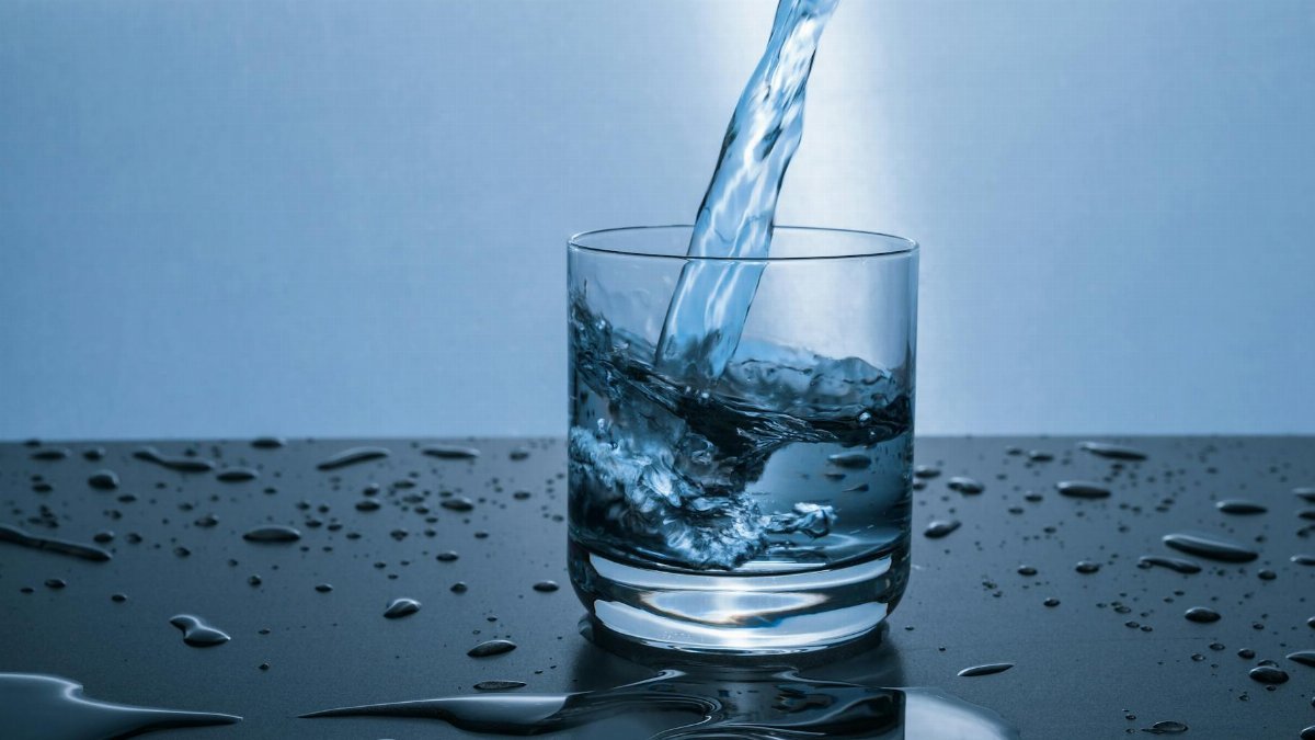 High-quality image of water being poured into a glass, illustrating hydration and purity.