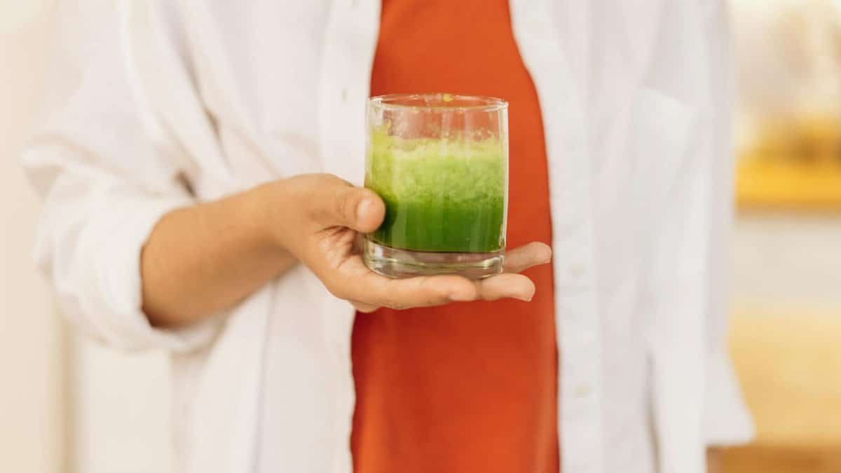 Close-up of a person holding a refreshing green smoothie, symbolizing a healthy lifestyle.