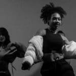 Captivating black and white photo of women dancing energetically indoors.