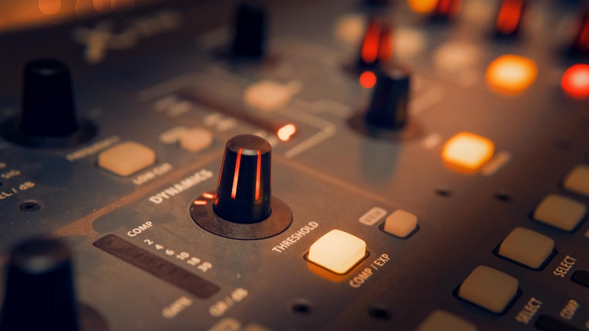 A detailed view of an audio mixer with glowing knobs, perfect for music production themes.