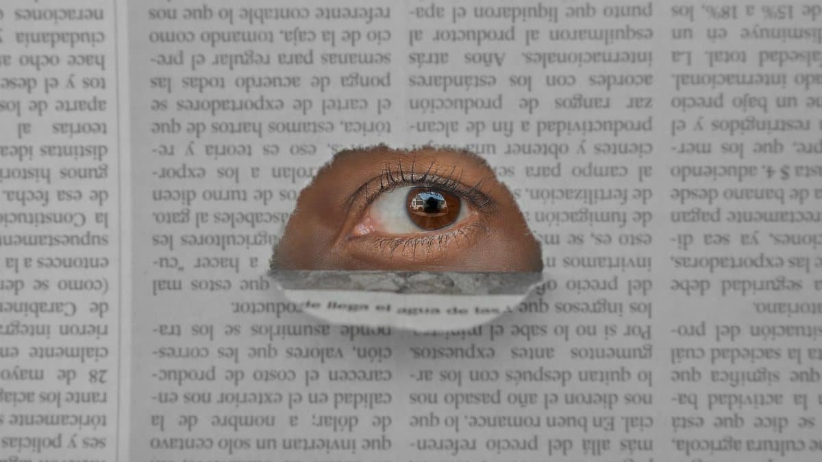 Artistic image of an eye peering through a hole in a newspaper, symbolizing insight and observation.