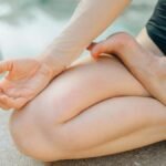 Close-up of a person meditating outdoors, focusing on a serene yoga pose for relaxation.