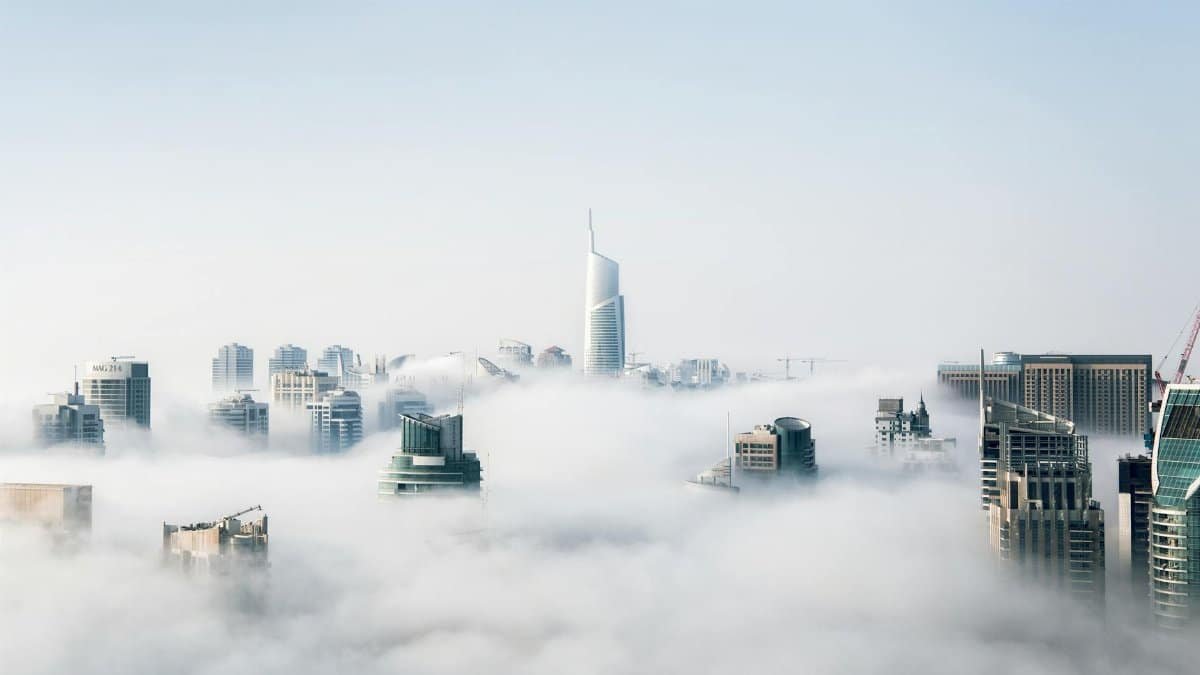 A stunning view of Dubai skyscrapers emerging through a blanket of fog, showcasing modern architecture.