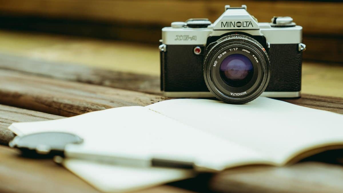 Classic Minolta film camera with a vintage lens on a wooden table, capturing a nostalgic feel.