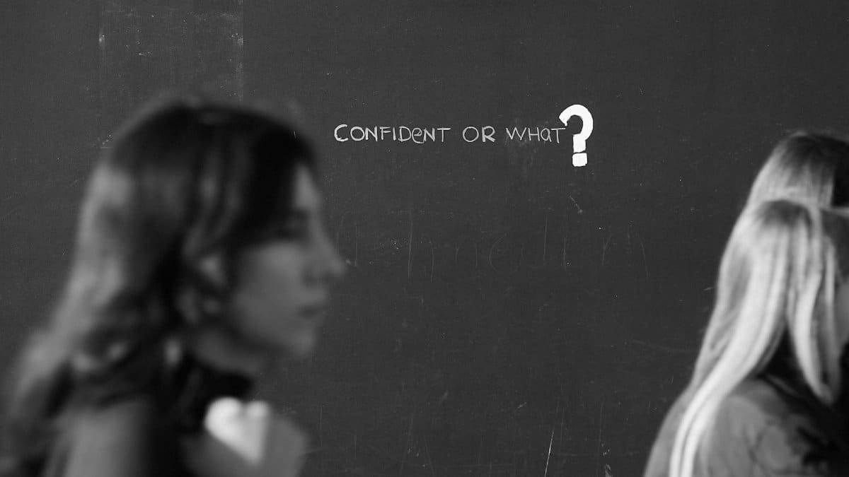 A thought-provoking black and white image featuring a question on confidence with blurred figures.