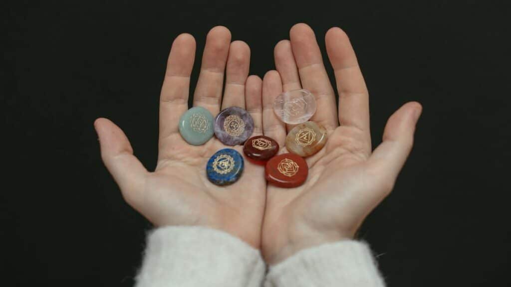 A close-up image of chakra stones held in open hands, showcasing spiritual balance.