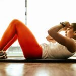 Young woman practicing yoga indoors, focusing on balance and fitness.