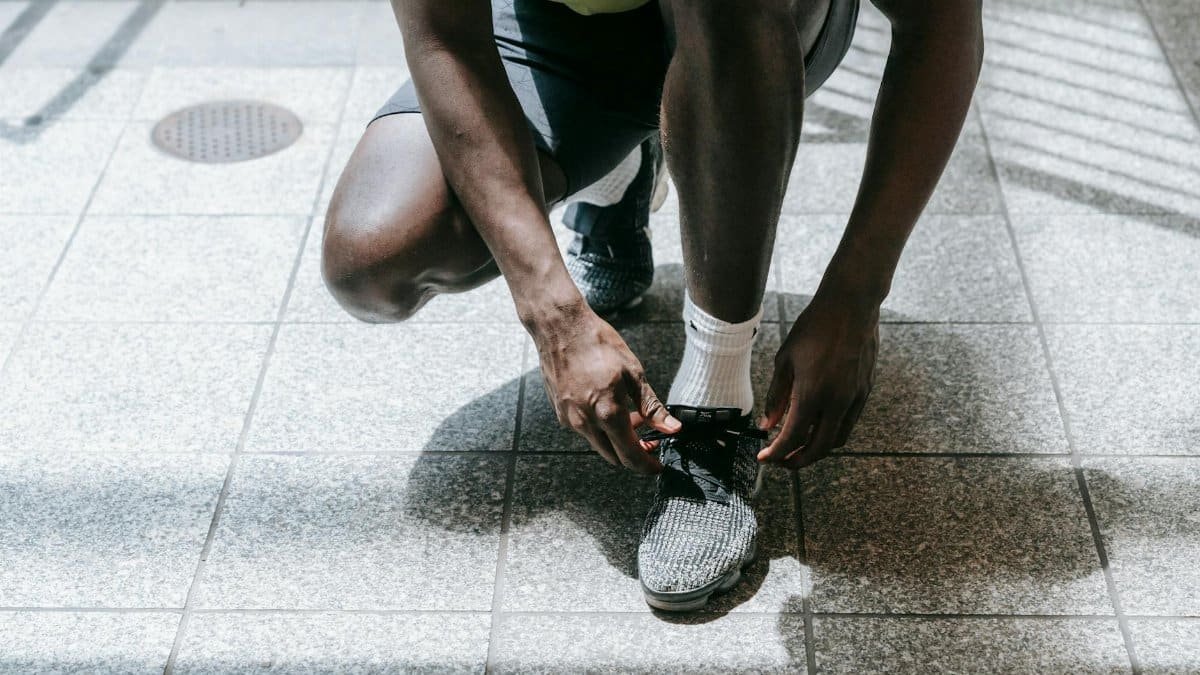 Close-up of an athlete tying sneakers, ready for training in an urban environment.