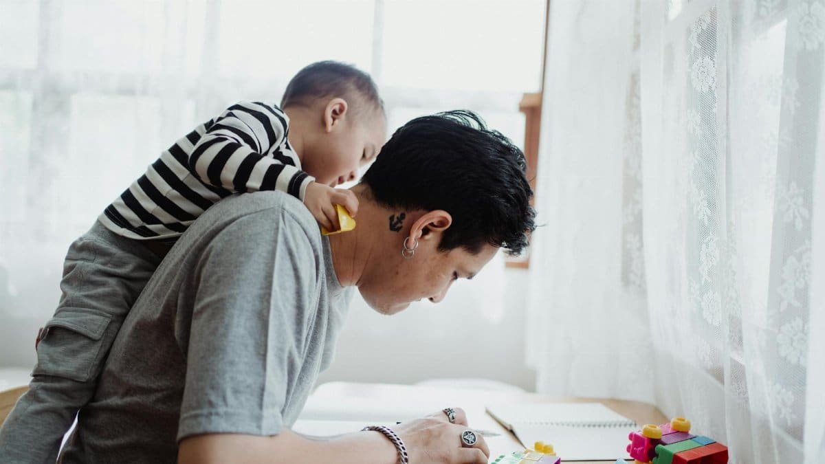Father and son play with colorful blocks indoors, capturing a joyful bonding moment.