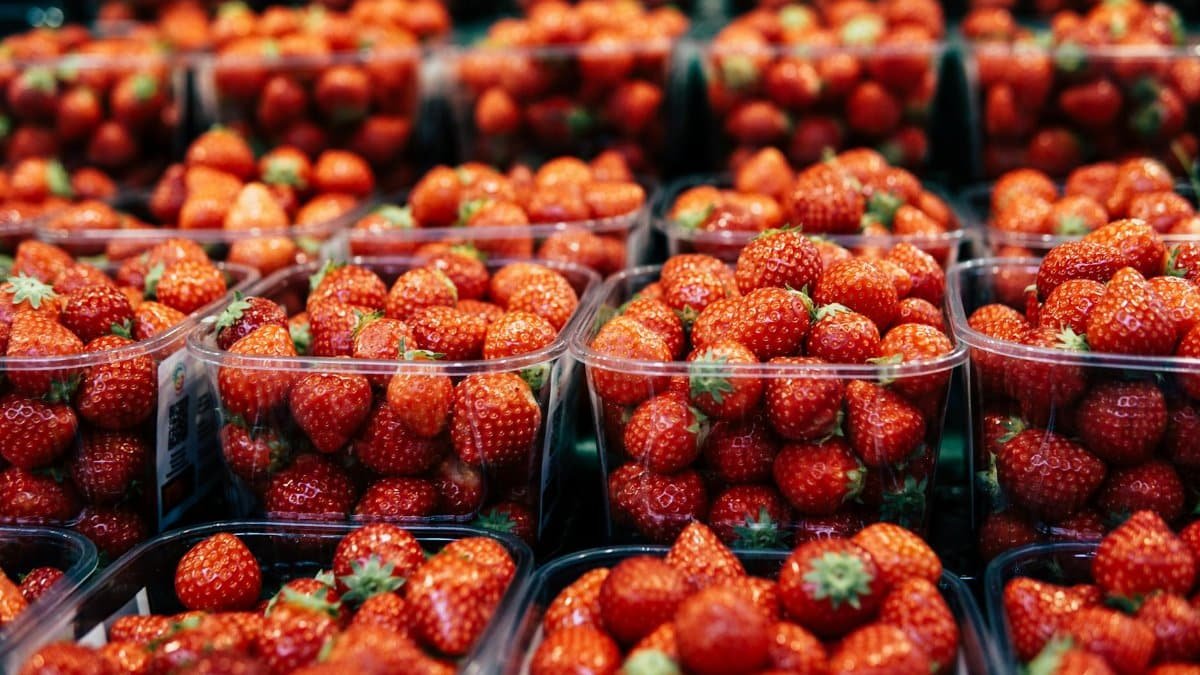Bright and juicy strawberries packed in containers at a market. Perfect for healthy snacks.