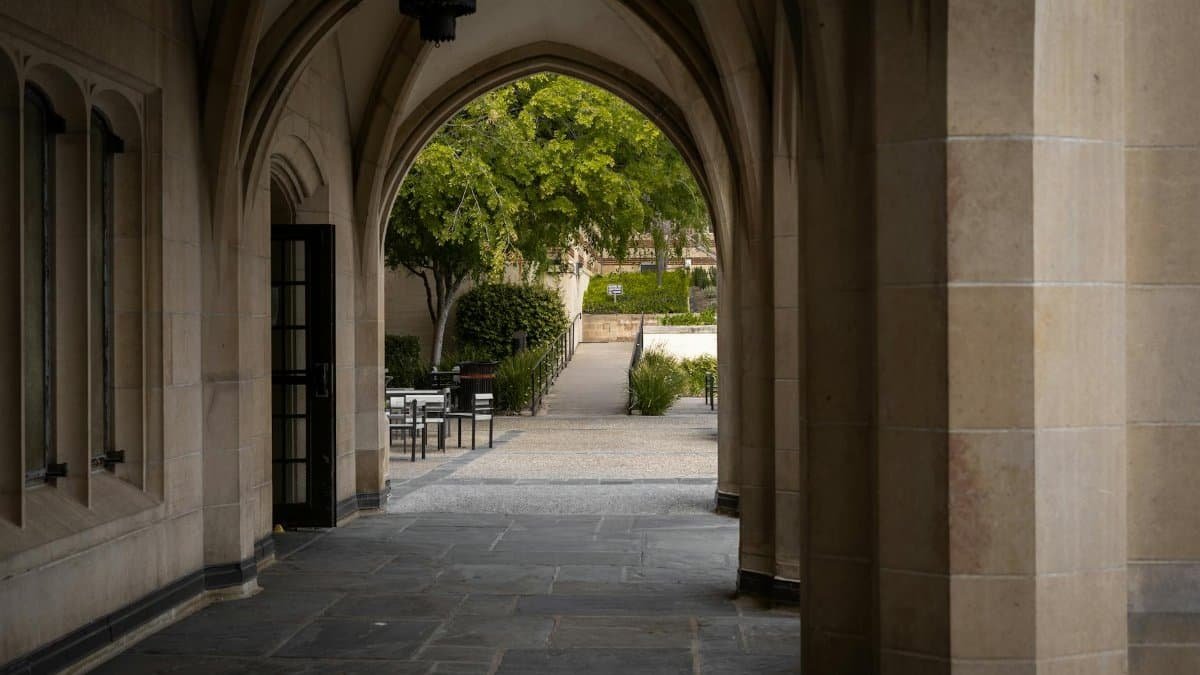 A serene view of an arched walkway leading to a garden area on the UCLA campus in Los Angeles.