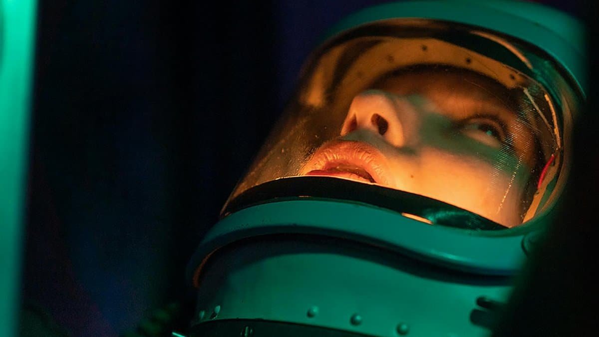 Close-up portrait of an astronaut looking upward, enshrined in colorful lighting.