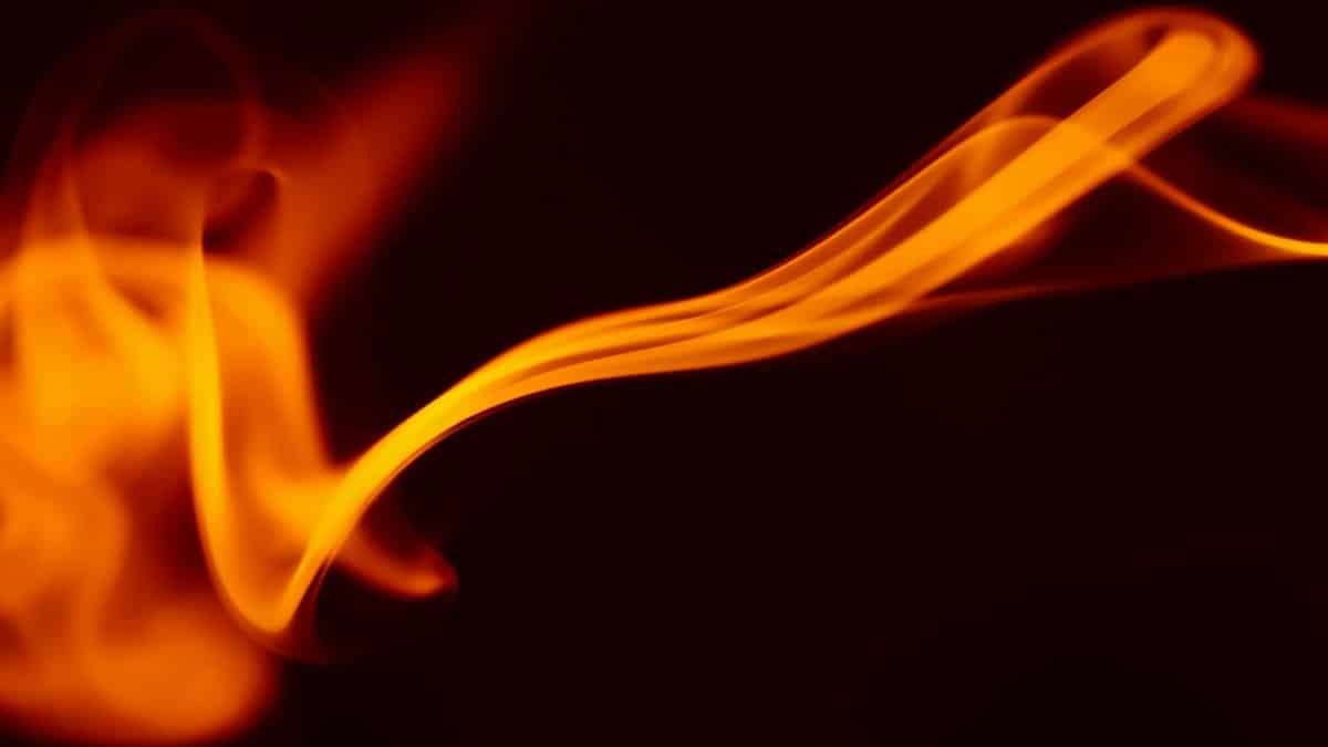 Blurred abstract flame captured in motion, evoking a sense of energy and heat against a dark backdrop.