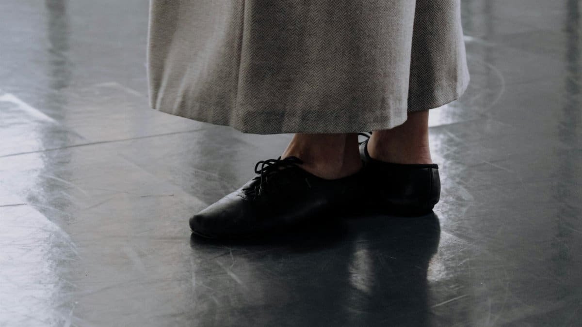 Artistic close-up of dance shoes on a studio floor, emphasizing movement.