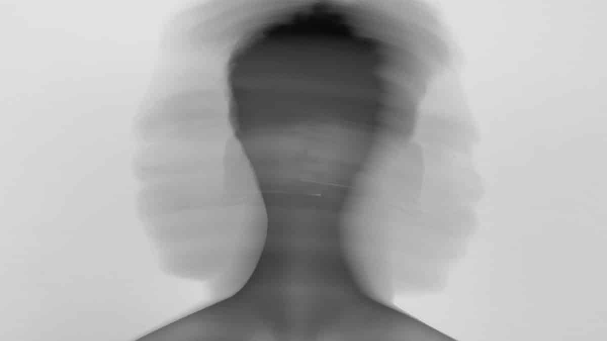 Abstract black and white portrait with blurred motion conveying emotional stress.