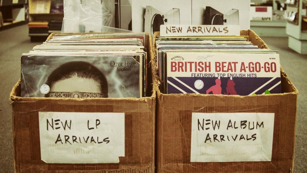Explore a vintage record store with boxes of new LP and album arrivals.