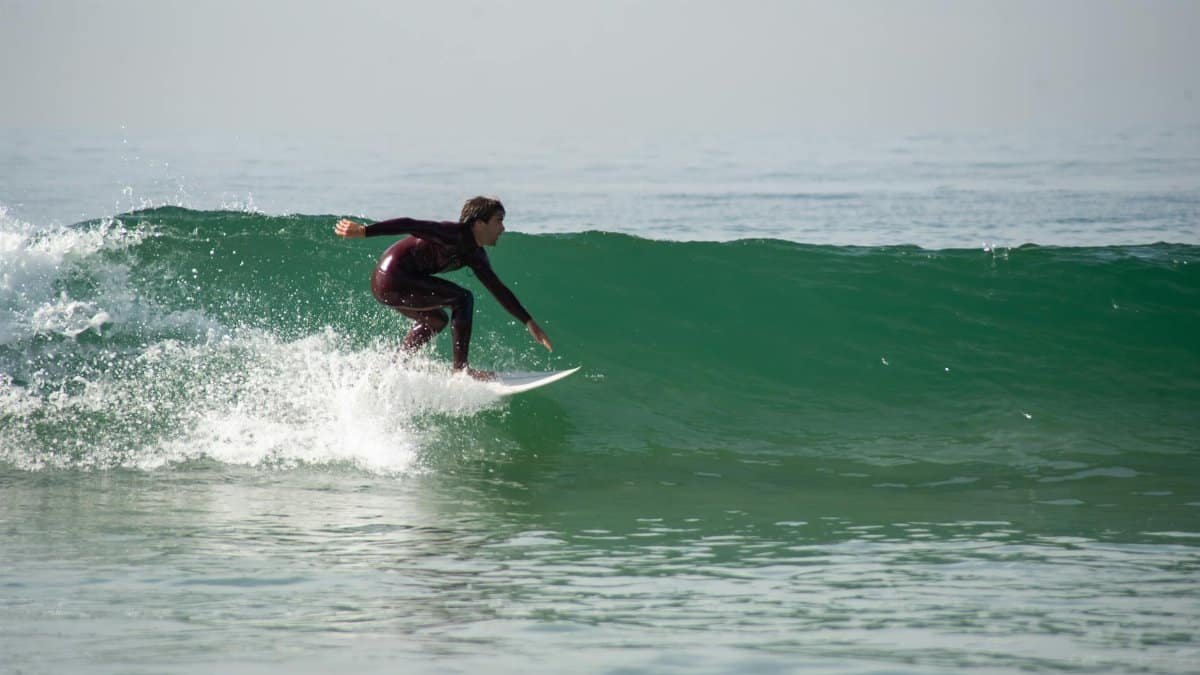 A surfer enjoying a perfect wave on a sunny day at a Portuguese beach.