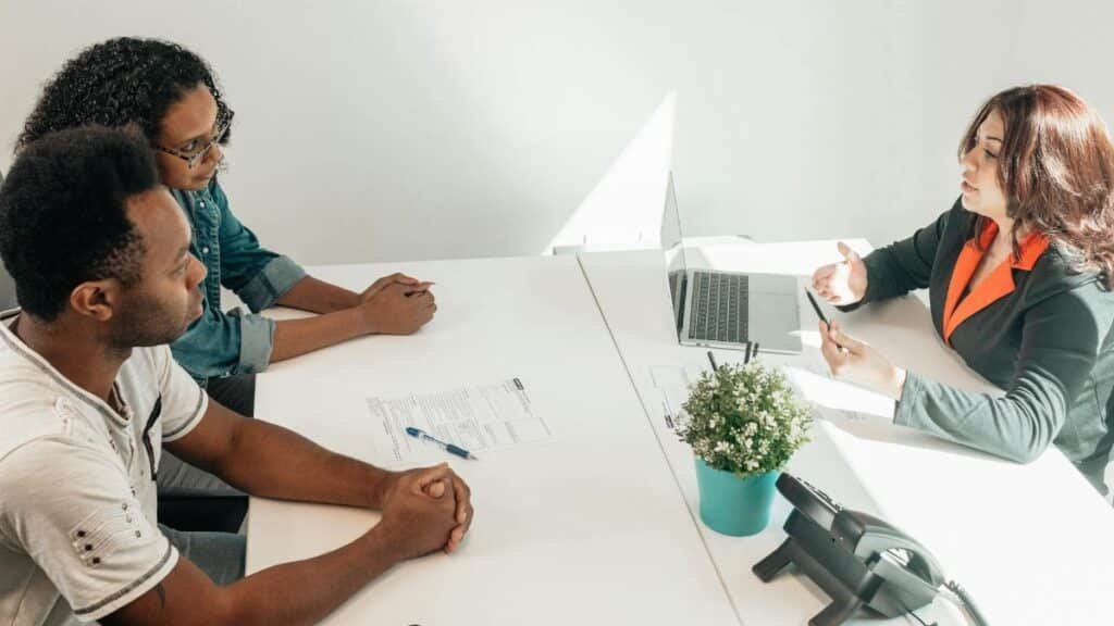 Two adults consulting a legal advisor in a modern office setting.