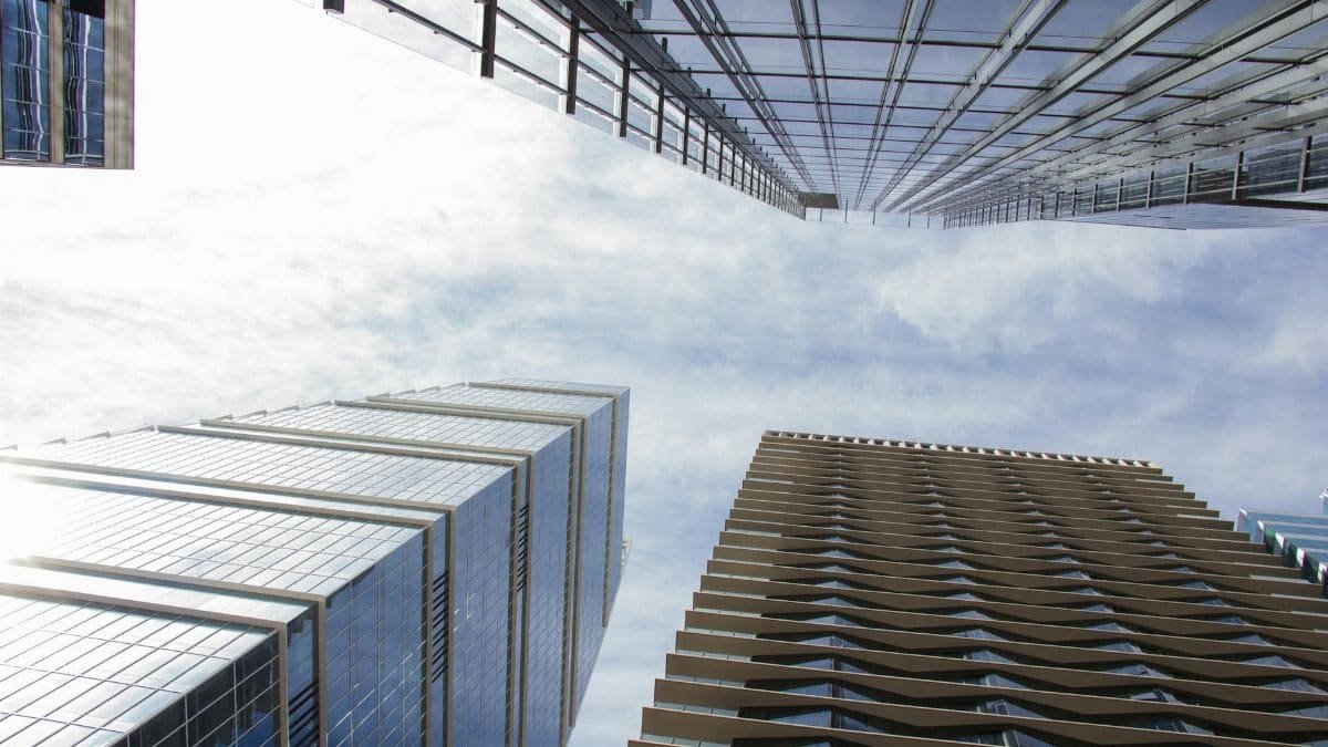 Low-angle view of high-rise buildings against a bright blue sky in Austin, Texas.