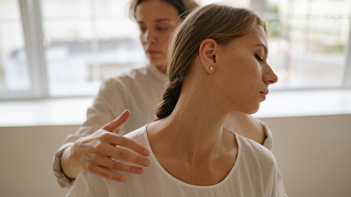 Two women engaged in a calming massage session, promoting wellness and relaxation.