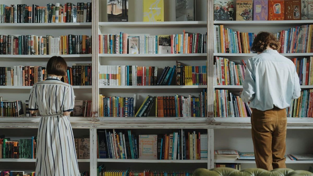 Two people browsing books in a cozy library, searching for their next great read.