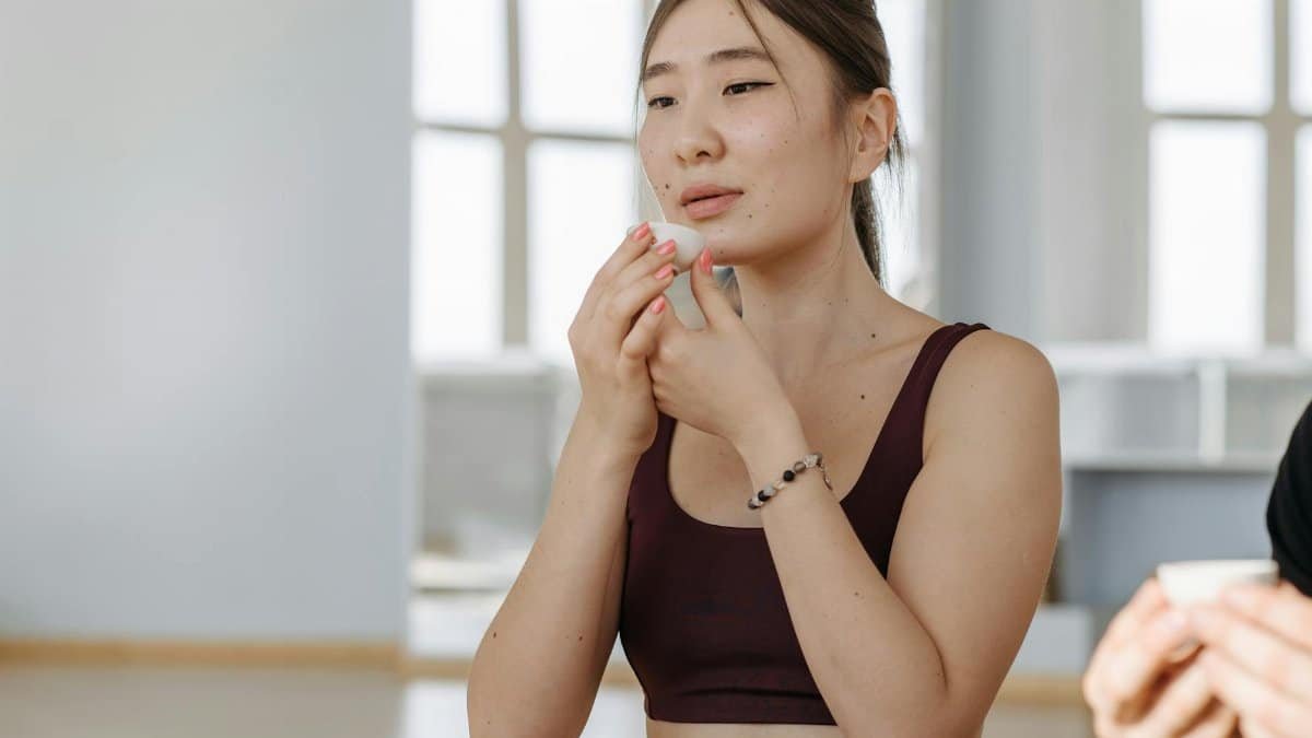 Woman savoring a cup of tea while relaxing indoors, conveying peace and mindfulness.