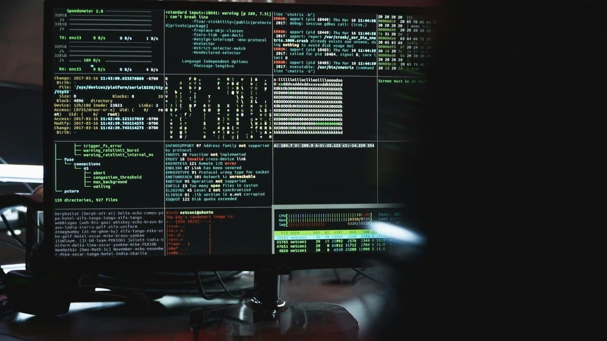 Close-up of a computer monitor displaying cyber security data and code, indicative of system hacking or programming.