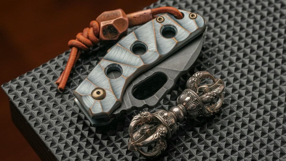 Detailed view of a vagha and industrial metal tool with leather cord on a textured surface. Ideal for themes of craftsmanship and spirituality.