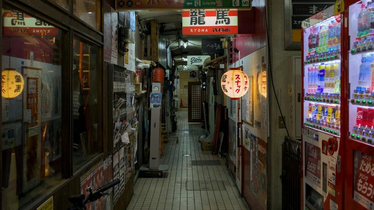 Explore a narrow alley in Kyoto at night, adorned with lanterns and vending machines. Perfect blend of tradition and modernity.