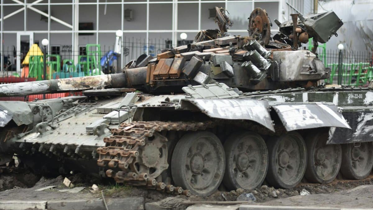 A destroyed military tank in an urban environment showcasing war damage.